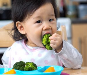 Child eating broccoli